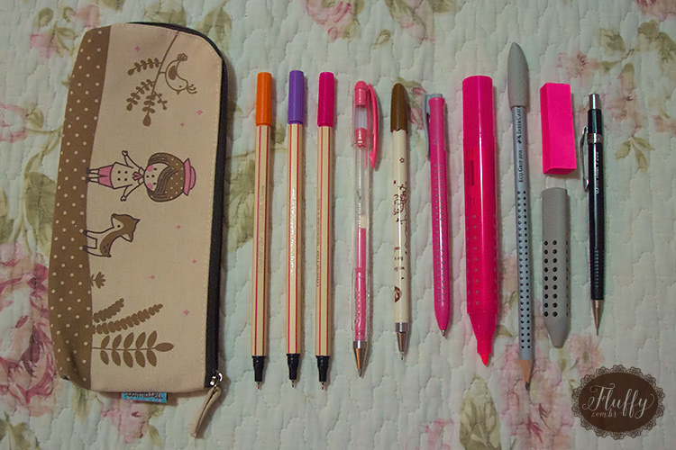 Estojo com: canetas coloridas + caneta gel na cor rosa + caneta preta + caneta simples na cor rosa + marcador de texto + lápis + post-its + borracha + lapiseira.